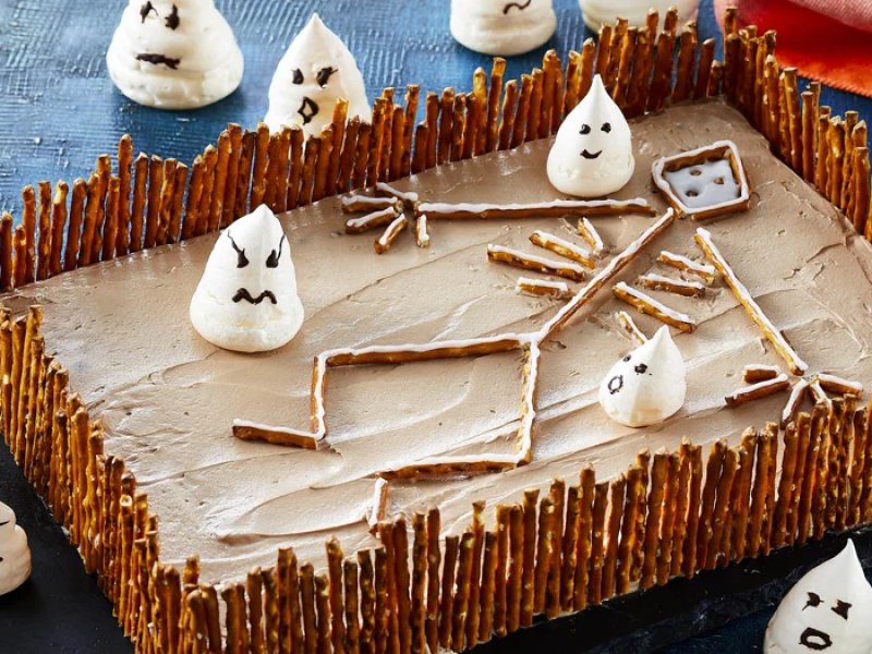 Halloween chokoladekage - Små hvide marengsspøgelser danser på denne kirkegårdskage med skeletter og sk...