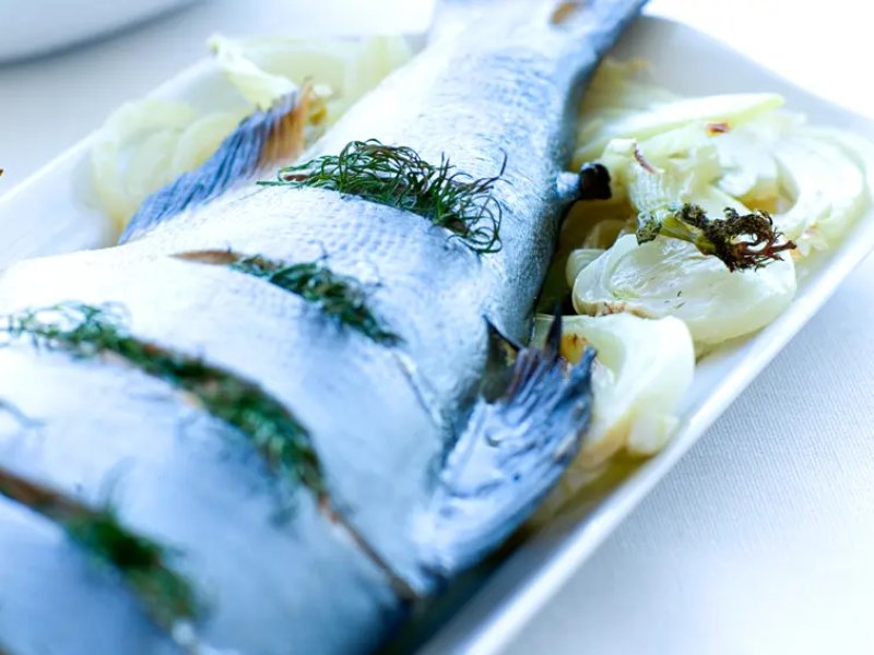 Ovnbagt ørred med krydderurter - Ovnbagt ørred på en bund af fennikel og toppet med dild og citron. Serveres m...