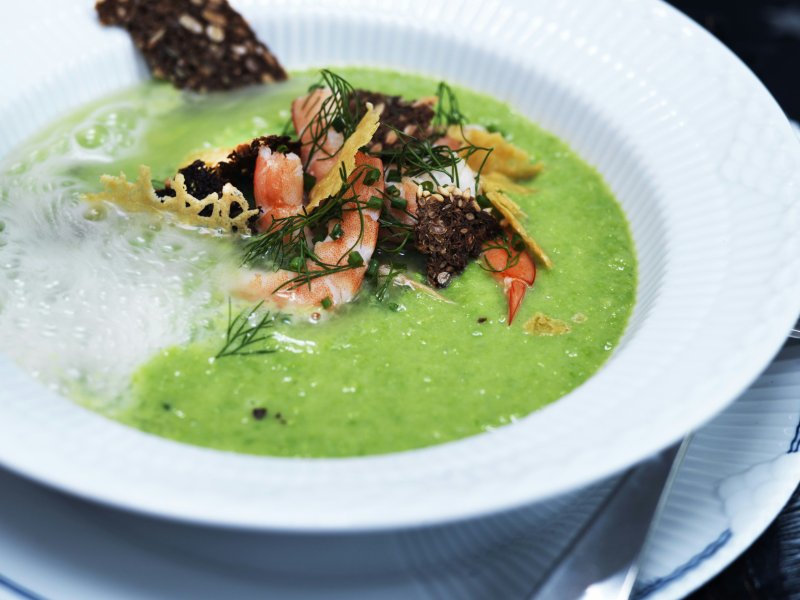 Ærtesuppe med champagne, rejer og rugbrødscrunch - Denne ærtesuppe må være årets smukkeste! Hæld champagne i den portionsanrette...