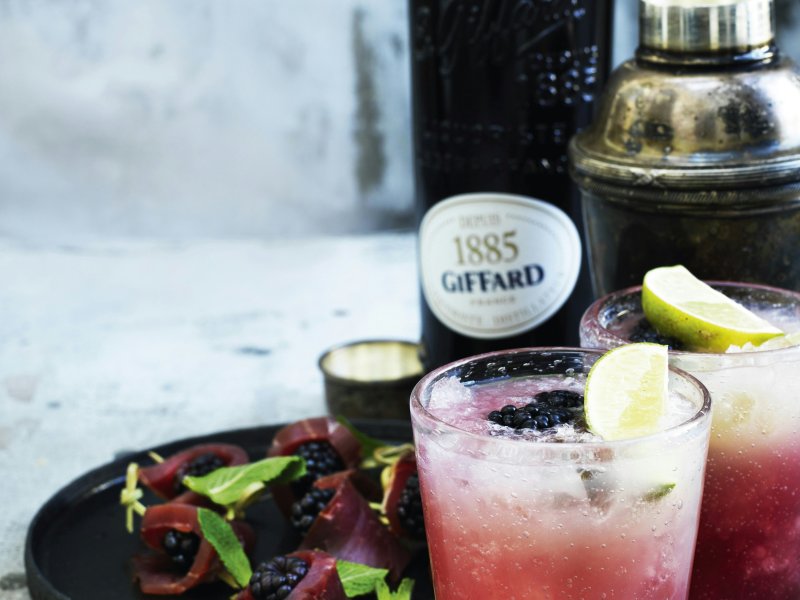 Bramble med snack af røget svinemørbrad - Bramble er en frisk drink, der forener gin, citrus og bærlikør. Servér den sa...